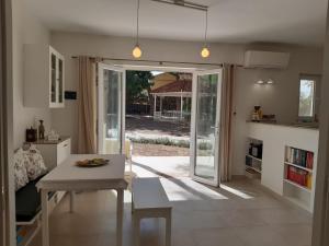 ein Wohnzimmer mit einem Tisch und einer Tür zum Hof in der Unterkunft Casa Kiosko 3 bedroom chalet with swimming pool in L'Eliana