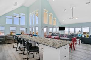 a room with a bar with chairs and a living room at DayDreamer Beachfront w 7 Bedrooms in Gilchrist