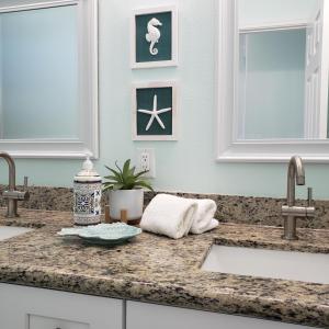 Una encimera de cocina con dos lavabos y dos espejos. en DayDreamer Beachfront w 7 Bedrooms, en Gilchrist 59 fotos más