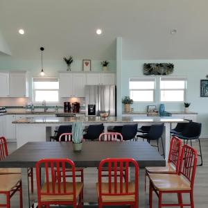 Una cocina con una mesa con sillas rojas y un mostrador. en DayDreamer Beachfront w 7 Bedrooms, en Gilchrist