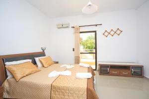 a bedroom with a bed with a tv on it at Maria Apartments "by Checkin" in Hersonissos