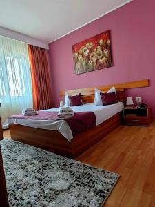 Un pat sau paturi într-o cameră la Hotel Triumph