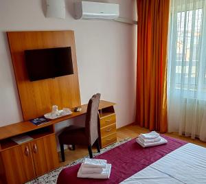 Un pat sau paturi într-o cameră la Hotel Triumph