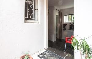 a hallway of a house with a red chair at Garden Cottage in Richmond nr Melville in Johannesburg