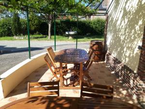 a wooden table and chairs on a patio at Hôtel de la Risle in Ambenay