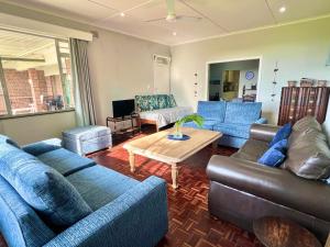 a living room with blue couches and a coffee table at St Lucia Holiday Cottage in St Lucia