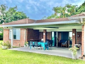a brick house with a patio with a table and chairs at St Lucia Holiday Cottage in St Lucia