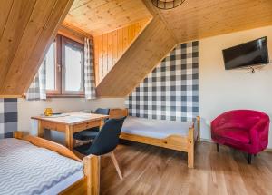 a room with a bed and a desk and a table at Na Równej Bieszczady in Polańczyk
