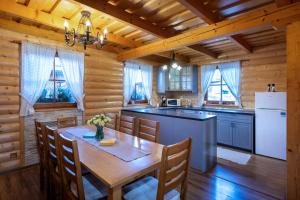 a kitchen and dining room with a table in a cabin at Tatralake Log Cabin - Drevenica pri Mare in Liptovský Mikuláš