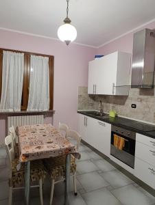 a kitchen with a table with chairs and white cabinets at Da Cinzia in Zanica