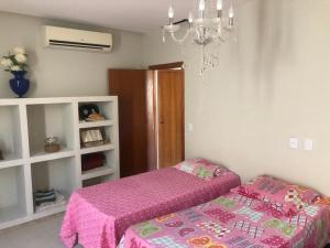 a bedroom with two beds and a chandelier at Alcobaça Beach House in Alcobaça +15 photos
