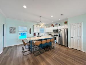 una cocina con isla con taburetes de bar en SeaDreams! 3BR Beachfront w Gorgeous Views and Steps to Sand, en Gilchrist