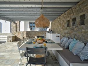 una sala da pranzo con un tavolo e un divano di IOKASTI LUXURY VILA with private pool & sea views-12 guests a Drios