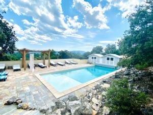 a swimming pool with chairs and a pergola at Villa Asunda B&B Spa & Sauna, Chambres d'Hôtes in Saint-Maximin-la-Sainte-Baume
