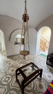 a living room with a glass table and a swing at Beit El-Abd Valley of Queens View in Al Aqālitah