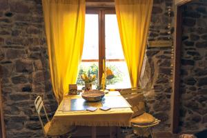 a table in a room with a window with yellow curtains at Maison de charme avec vue exceptionnelle in Monteils