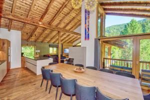 kuchnia i jadalnia z dużym drewnianym stołem i krzesłami w obiekcie Chalet Schmitten - by Alpen Apartments w mieście Zell am See