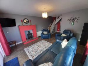a living room with a couch and chairs and a fireplace at Ballyallaght House in Bushmills