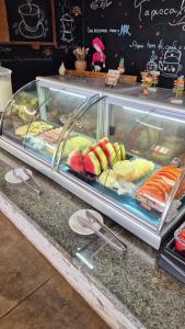 obudowa z sushi i innym jedzeniem na ladzie w obiekcie Pousada America do Sol w mieście Natal