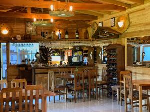 a restaurant with wooden tables and chairs and a bar at Hotel Boutique La Casa de Coco in Gorbea