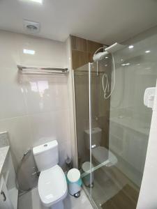 Un baño con inodoro y ducha de cristal. en Pouso do encanto, en Salvador