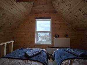 a room with two beds and a window in a cabin at The Perfect Stop - Pinewood Loft in Lødingen