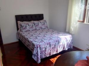 Una cama en una habitación con un edredón morado. en Apartamento aconchegante na serra!, en Miguel Pereira 26 fotos más