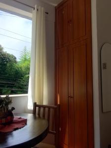 Un comedor con una mesa y un gran ventanal. en Apartamento aconchegante na serra!, en Miguel Pereira
