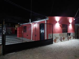 un edificio rojo con una puerta por la noche en Alquileres temporarios Anahi, en Las Heras