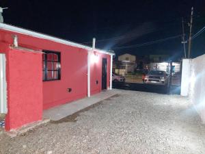 un edificio rojo con una puerta roja por la noche en Alquileres temporarios Anahi, en Las Heras 2 fotos más