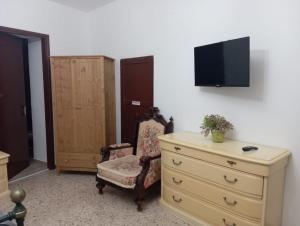 a bedroom with a dresser and a tv on a wall at ELICO A Sicily in Sambuca di Sicilia