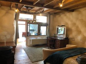 a bedroom with a bed and a desk and a mirror at Rabbits 1or 2 bedroom hobbit style hillset earthen dartmoor eco home in South Brent