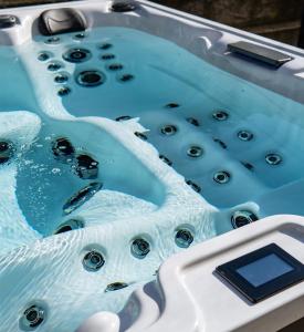 a bath tub filled with blue water with bubbles at Apartment Dujić with hot tub in Kaštela