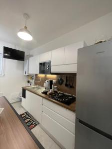 a kitchen with white cabinets and a stainless steel refrigerator at Nigalù House in Naples