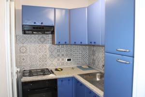 a kitchen with blue cabinets and a sink at Gelsomino I in Ustica