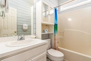a white bathroom with a sink and a toilet at Tan Lines in Dauphin Island +36 photos