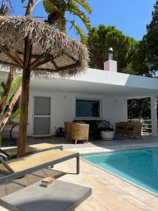 a resort with a swimming pool and an umbrella at El Mar, Pool House with 3 BDR, 7 min from beach in Saronida