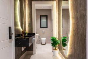 リヤドにあるAmber Hospitality - BLVDの洗面台、トイレ、鏡のあるバスルーム +283枚の写真