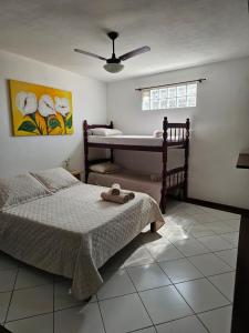 a bedroom with two beds and a bath tub at Casa Cacau - Guest house a 700m metros de geriba in Armacao dos Buzios