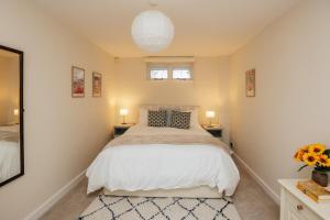 a bedroom with a large bed with two tables and two lamps at Garden Lodge in Aston Tirroid
