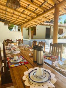 a wooden table with chairs and a wooden tableasteryasteryasteryasteryasteryasteryastery at Pousada Caminho da Praia Trancoso in Trancoso