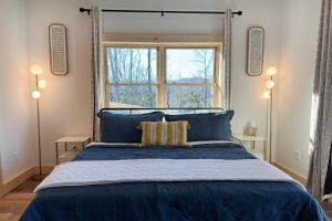 a bedroom with a blue bed with a window at Moksha Retreat in Black Mountain