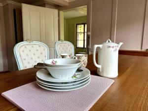 a table with a bowl and plates and a pitcher at Historical Guesthouse Rosalie in Brunnadern +53 photos