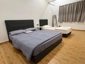 a bedroom with two beds in a room at M Guest House2 in Muar