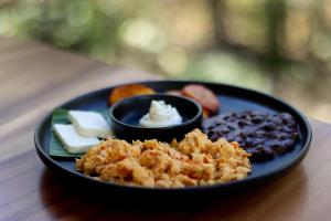 a black plate of food with beans and other foods at Aviva Hotel in Tzununá