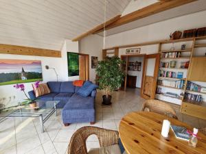 a living room with a blue couch and a table at Ferienwohnung Storchenblick in Raisting