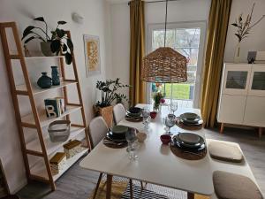 ein Esszimmer mit einem weißen Tisch mit Tellern und Gläsern in der Unterkunft Landhaus SoonZauber in Münchwald