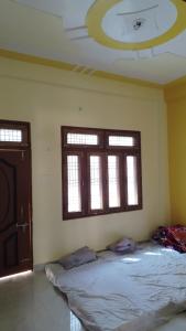 a bedroom with a bed and two windows at Ravi villa in Prayagraj