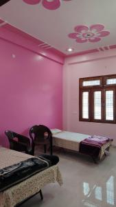 a room with two beds and a pink wall at Ravi villa in Prayagraj