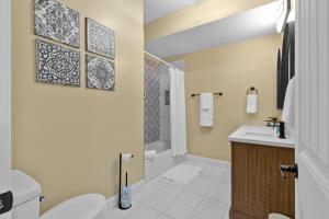 a bathroom with a toilet and a sink and a shower at Red Brick Hideaway in Soulard +34 photos